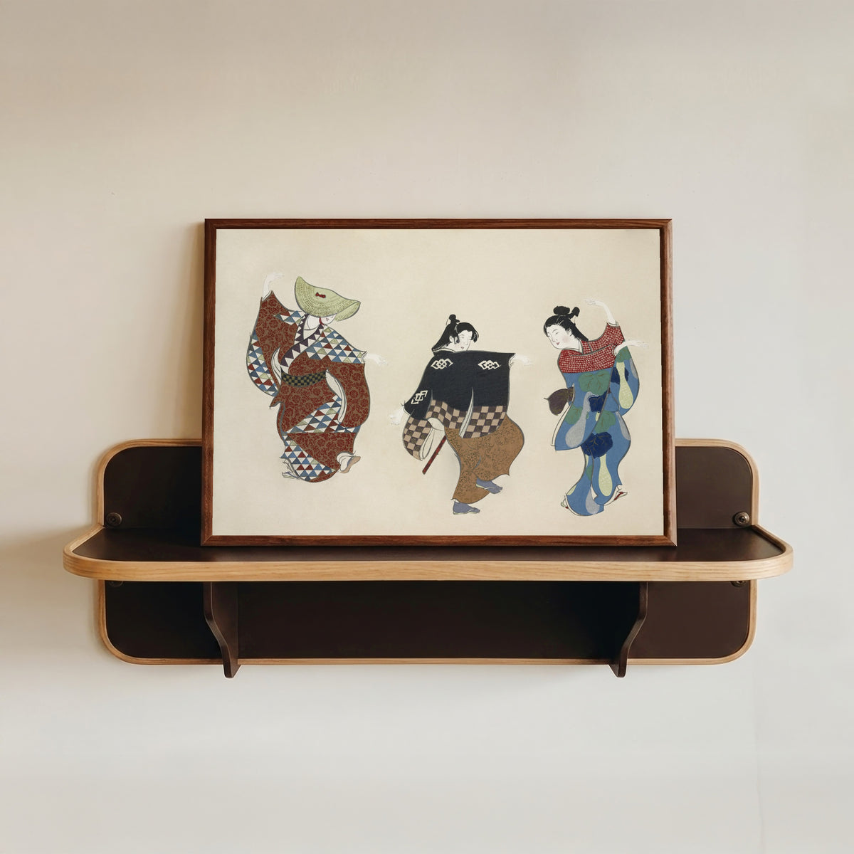 Framed art print of Dancers, from Momoyogusa by Kamisaka Sekka, in a dark wood frame resting on a wall shelf