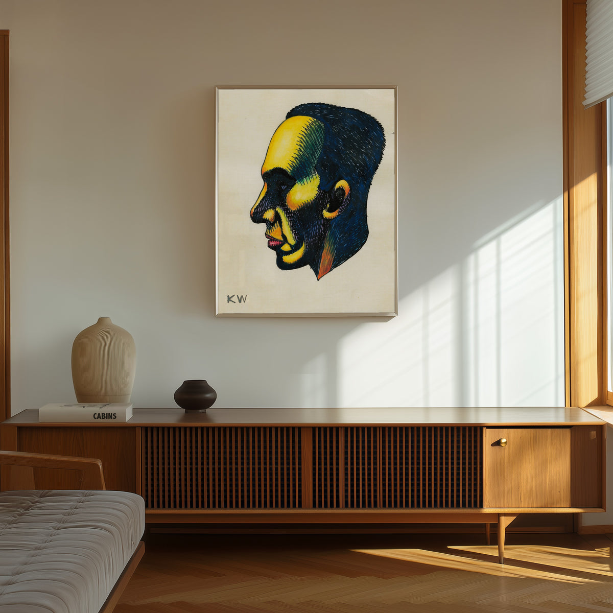 Framed art print of Profile Head Study No. 1 by Karl Wiener, in a thin light frame on a sunlit wall above a wooden sideboard