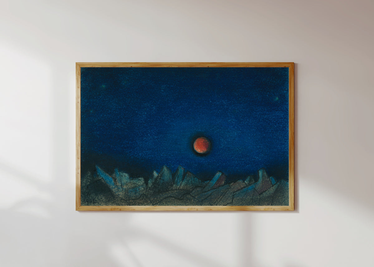 Framed art print of Untitled (Red Moon over a Landscape of Ruins) by Karl Wiener, in a light wood frame on a sunlit white wall