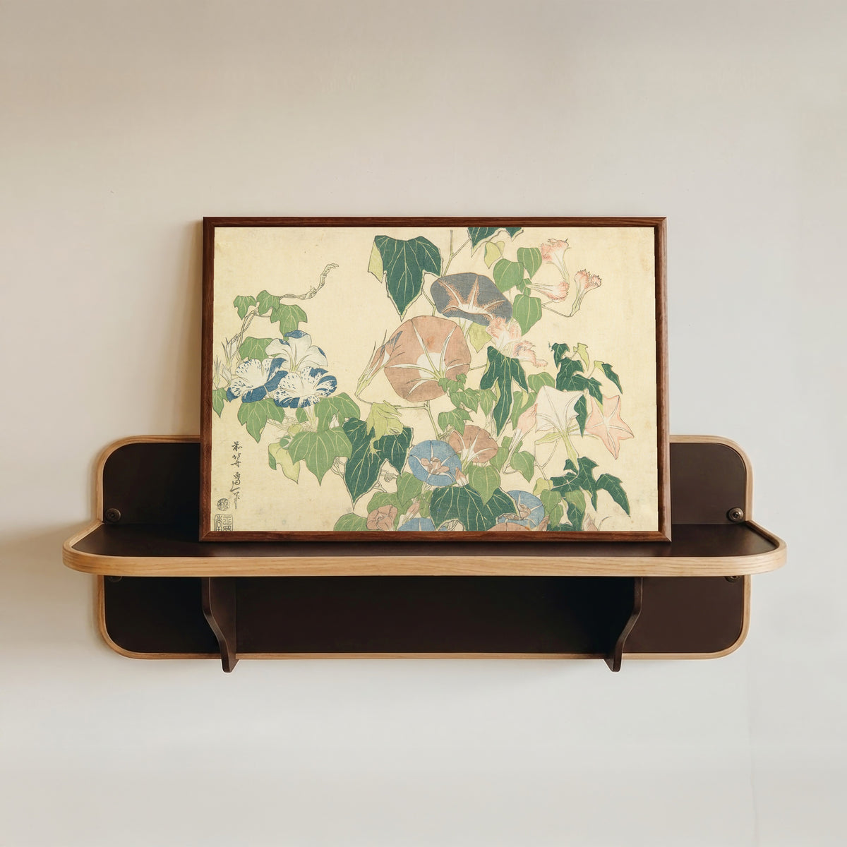 Framed art print of Large Flowers: Morning Glories and Tree-frog by Katsushika Hokusai, in a dark wood frame resting on a wall shelf
