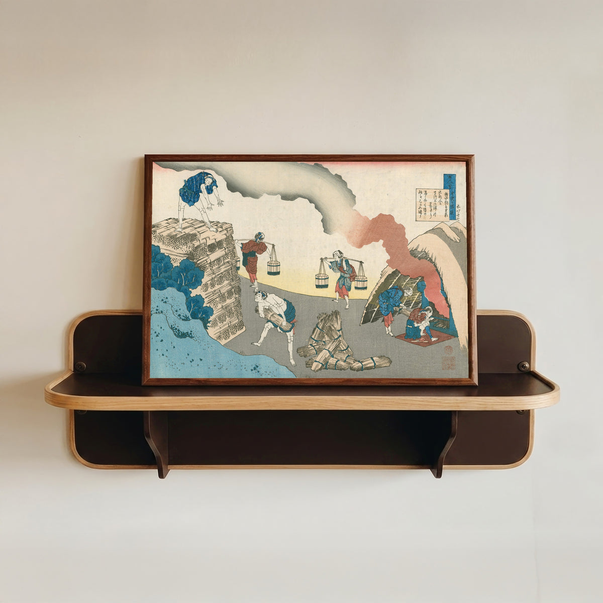 Framed art print of One Hundred Poems Explained by the Nurse: Poem by Gon-Chūnagon Sadaie by Katsushika Hokusai, in a dark wood frame resting on a wall shelf