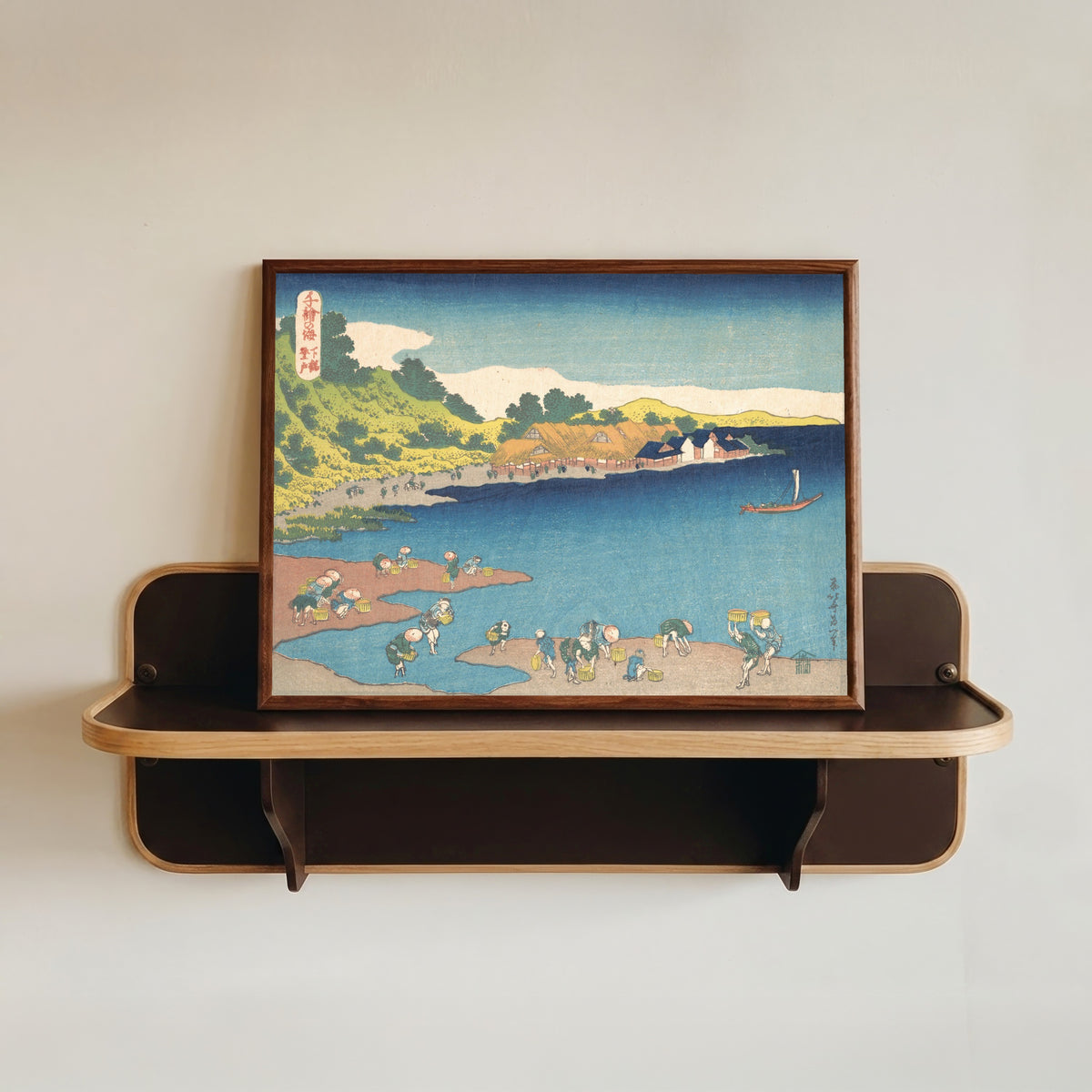Framed art print of One Thousand Pictures of the Sea: Noboto at Shimōsa by Katsushika Hokusai, in a dark wood frame resting on a wall shelf