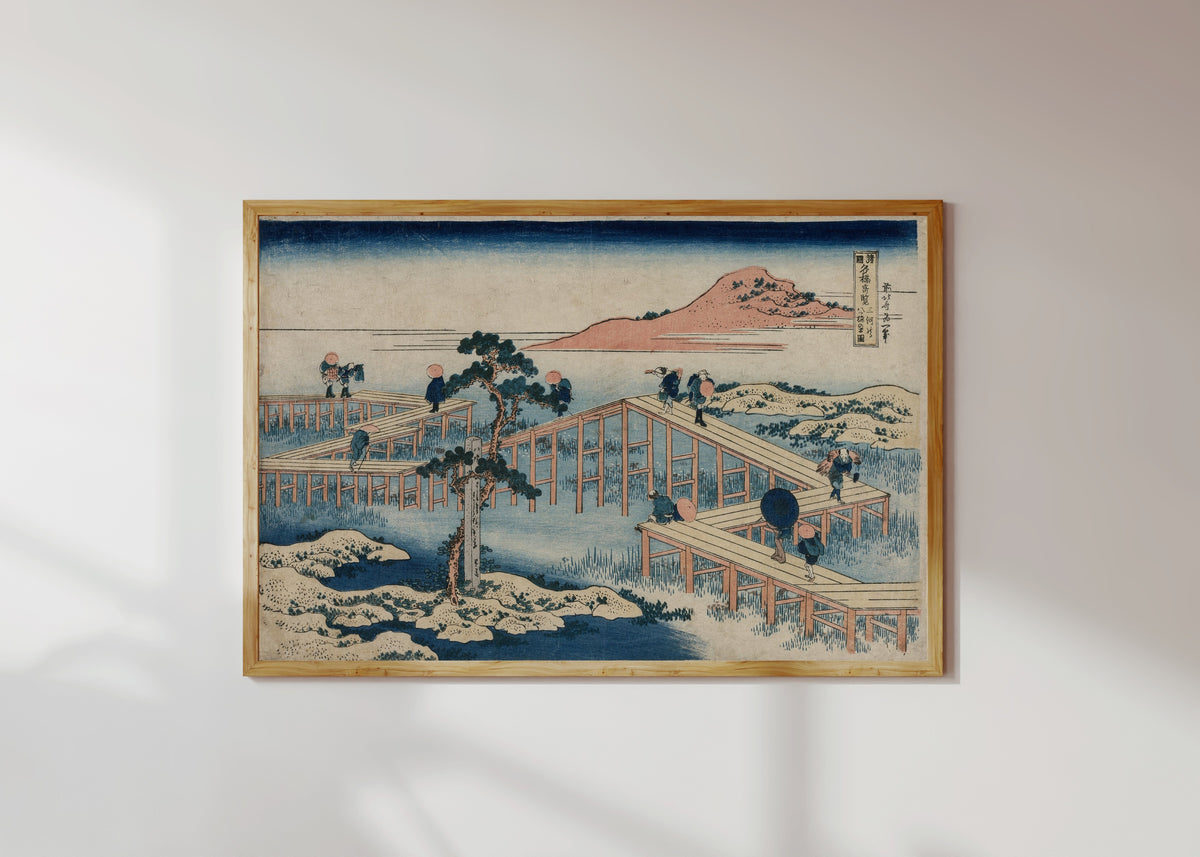Framed art print of Remarkable Views of Bridges in Various Provinces: An Ancient Picture… by Katsushika Hokusai, in a light wood frame on a sunlit white wall