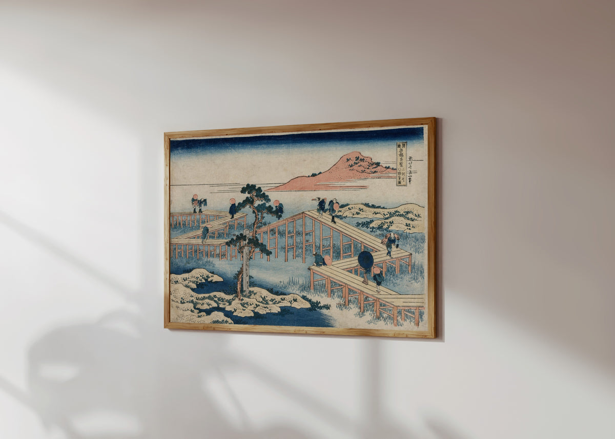 Framed art print of Remarkable Views of Bridges in Various… by Katsushika Hokusai, in a light wood frame on a sunlit white wall, seen at a slight angle