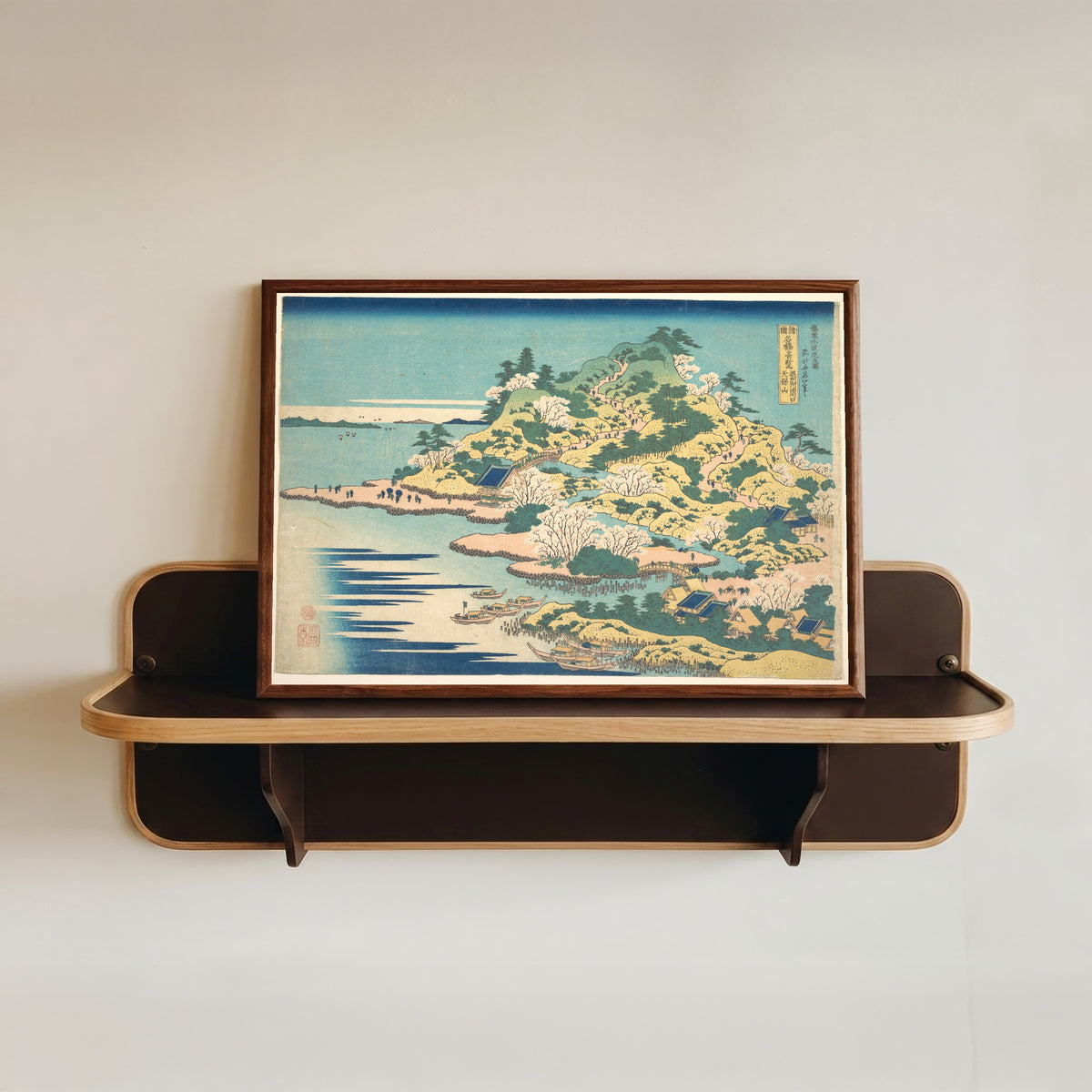 Framed art print of Remarkable Views of Bridges in Various Provinces: Tenpōzan at the… by Katsushika Hokusai, in a dark wood frame resting on a wall shelf