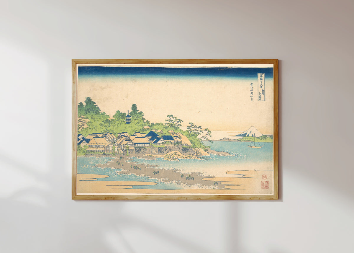 Framed art print of Thirty-six Views of Mount Fuji: Enoshima Island in Sagami Province by Katsushika Hokusai, in a light wood frame on a sunlit white wall