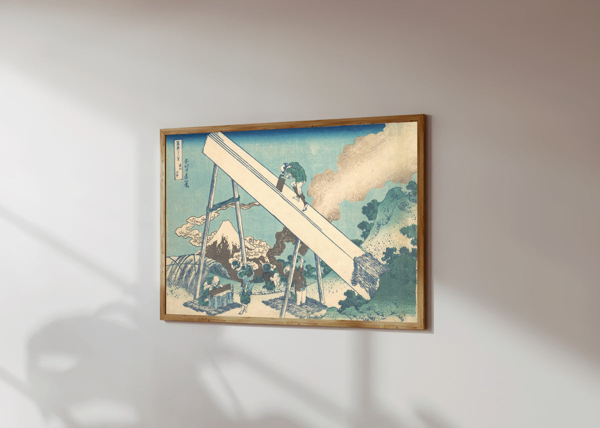 Framed art print of Thirty-six Views of Mount Fuji: In the… by Katsushika Hokusai, in a light wood frame on a sunlit white wall, seen at a slight angle