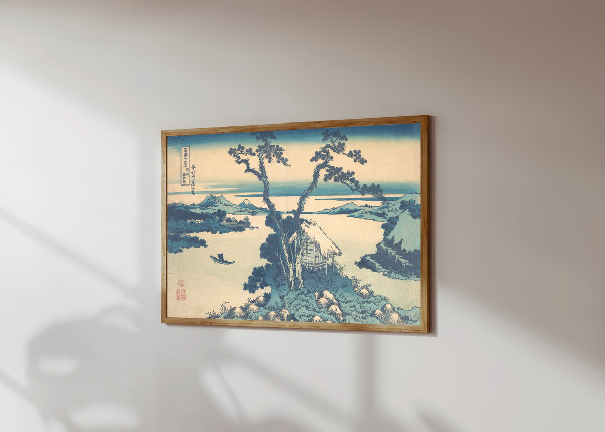 Framed art print of Thirty-six Views of Mount Fuji: Lake Suwa in… by Katsushika Hokusai, in a light wood frame on a sunlit white wall, seen at a slight angle
