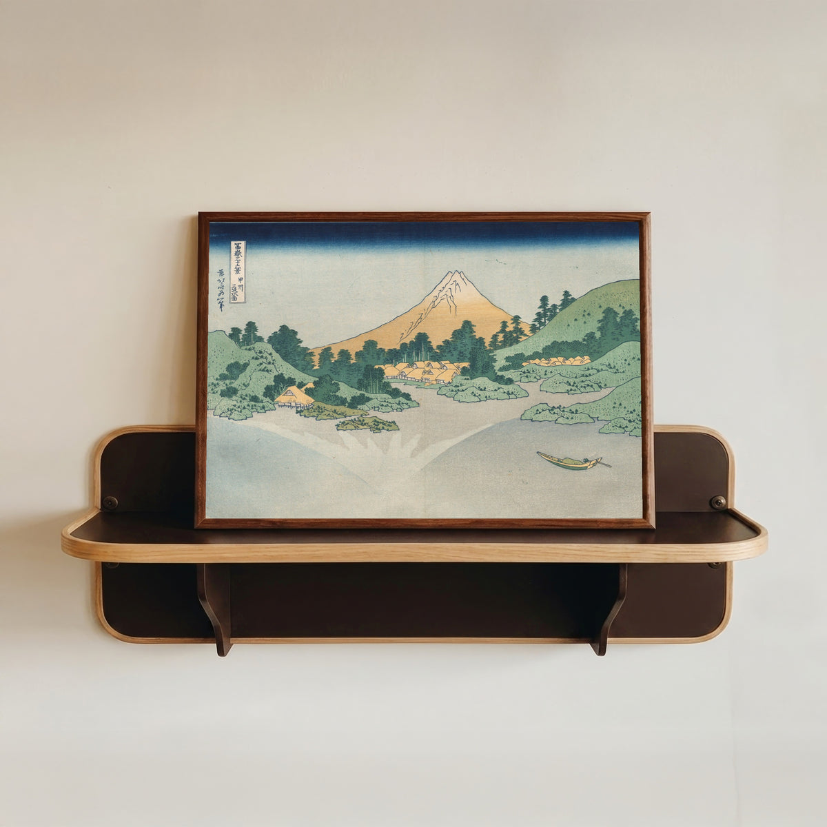 Framed art print of Thirty-six Views of Mount Fuji: The Surface of Lake Misaka in Kai… by Katsushika Hokusai, in a dark wood frame resting on a wall shelf