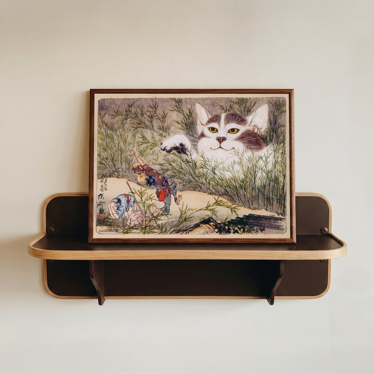 Framed art print of Seisei Kyōsai Album (Giant Cat in the Grass) by Kawanabe Kyosai, in a dark wood frame resting on a wall shelf