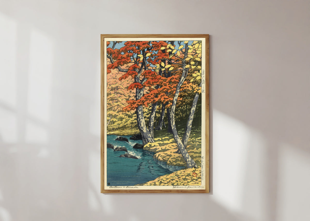 Framed art print of Autumn in the Forest by Kawase Hasui, in a light wood frame on a sunlit white wall