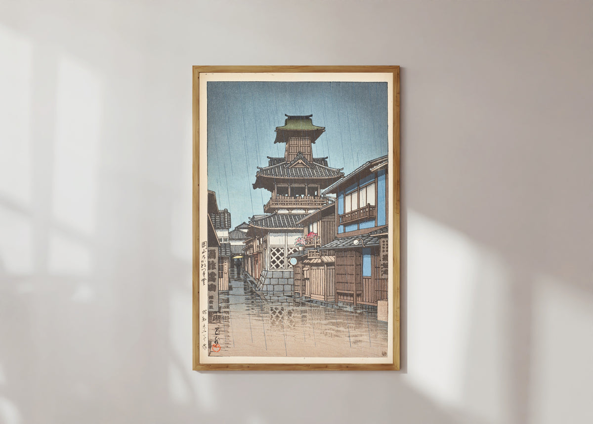 Framed art print of Bell Tower at Okayama by Kawase Hasui, in a light wood frame on a sunlit white wall