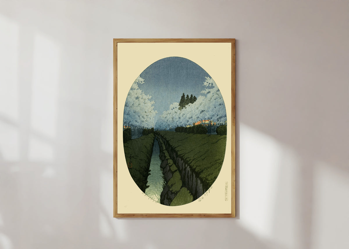 Framed art print of Cherry Blossoms at Koganei, Night by Kawase Hasui, in a light wood frame on a sunlit white wall