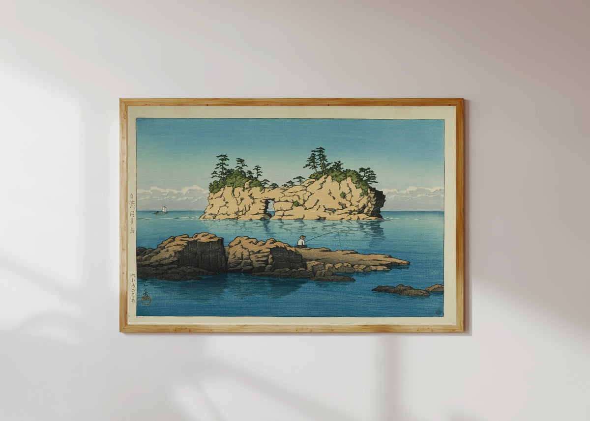 Framed art print of Engetsu Island, Shirahama by Kawase Hasui, in a light wood frame on a sunlit white wall