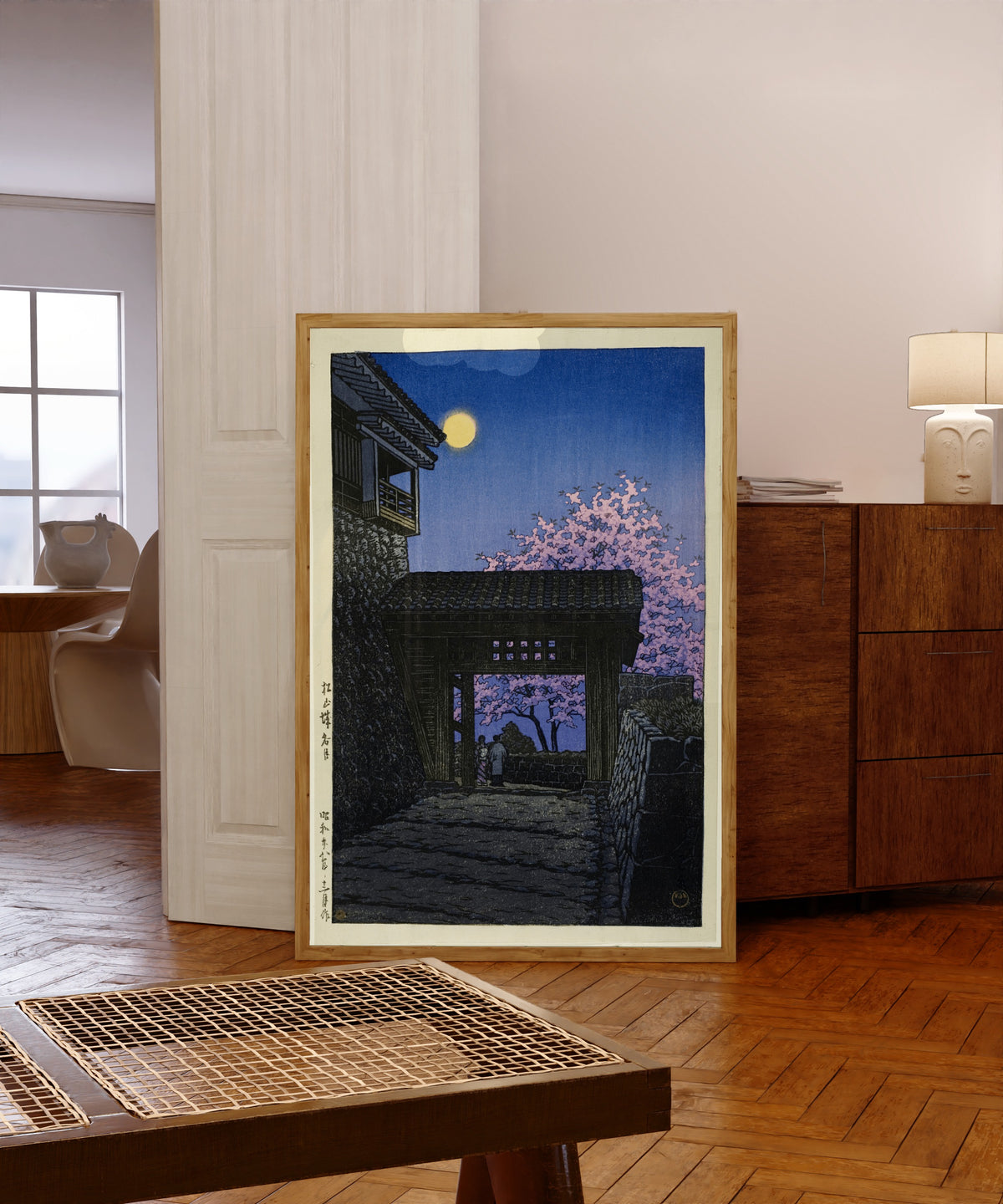 Framed art print of Evening at Matsuyama Castle by Kawase Hasui, in a light wood frame leaning in a warm room with a parquet floor