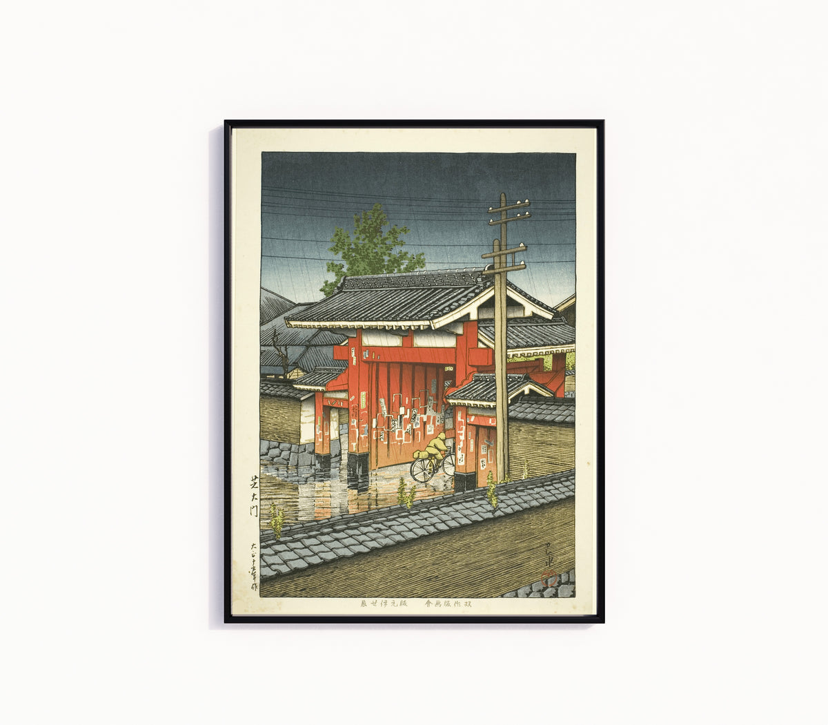 Framed art print of Great Gate at Shiba by Kawase Hasui, in a slim black frame on a plain white wall