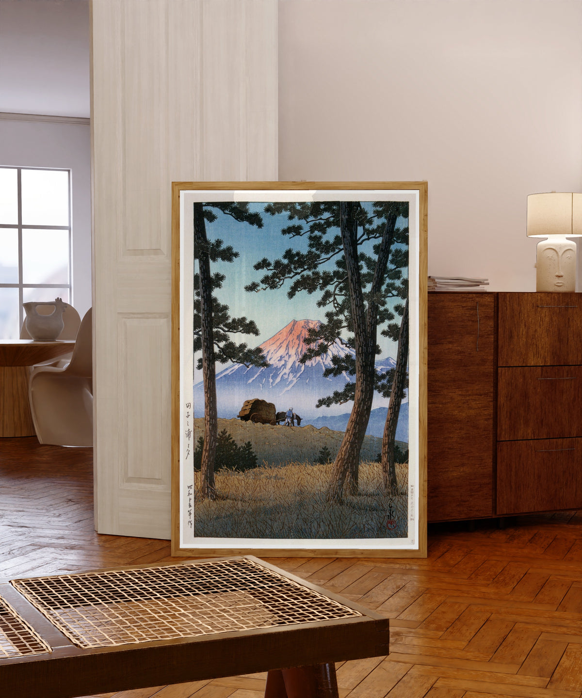 Framed art print of Fuji Mountain by Kawase Hasui, in a light wood frame leaning in a warm room with a parquet floor