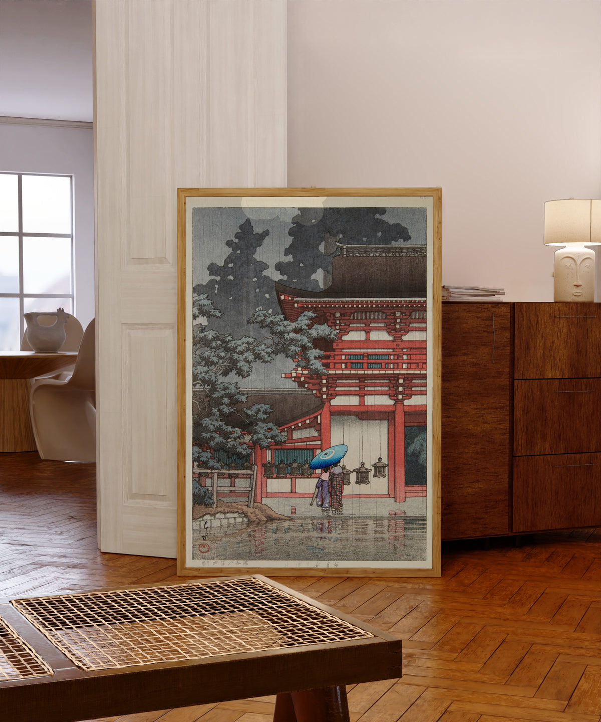 Framed art print of Kasuga Shrine, Nara by Kawase Hasui, in a light wood frame leaning in a warm room with a parquet floor