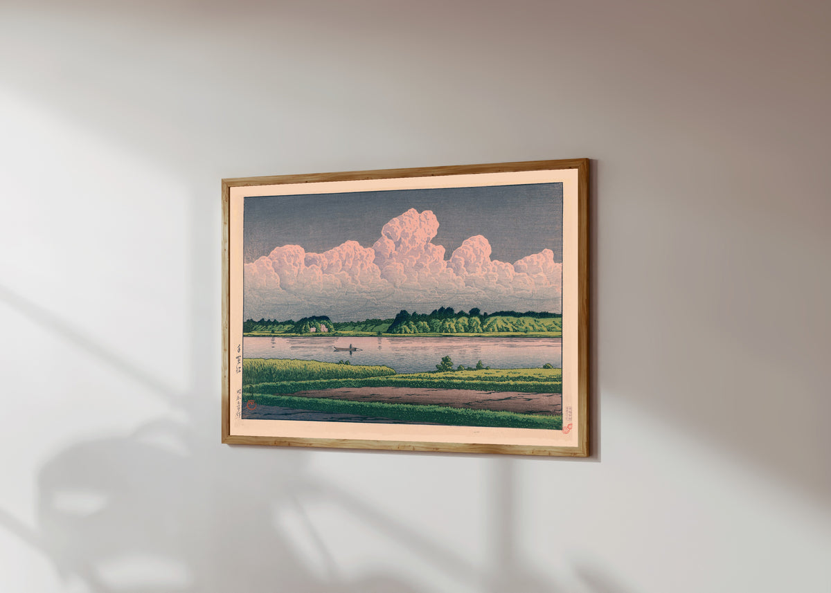 Framed art print of Lake Teganuma by Kawase Hasui, in a light wood frame on a sunlit white wall, seen at a slight angle