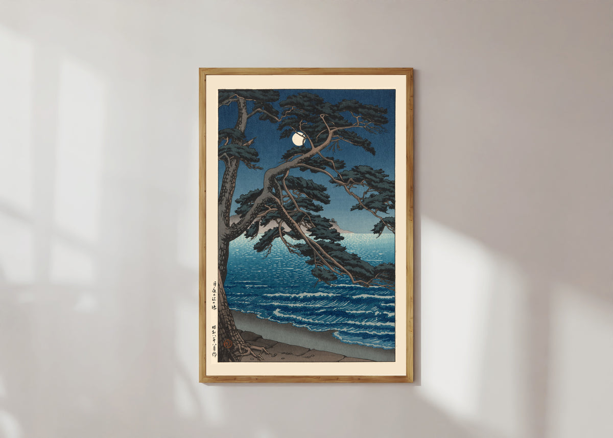 Framed art print of Moon at Enoshima Beach by Kawase Hasui, in a light wood frame on a sunlit white wall