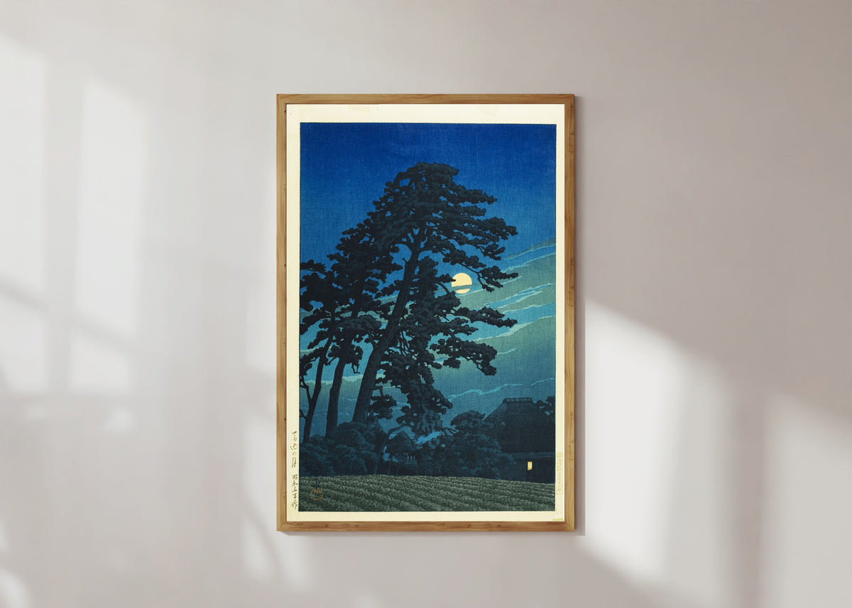 Framed art print of Moon at Umagome by Kawase Hasui, in a light wood frame on a sunlit white wall