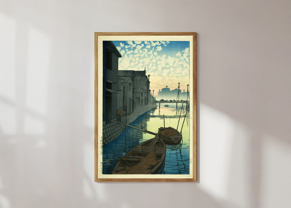 Framed art print of Morning at Daikon Wharf by Kawase Hasui, in a light wood frame on a sunlit white wall
