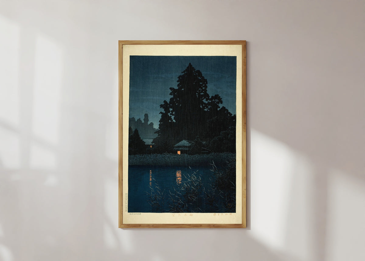Framed art print of Omiya in the Rain by Kawase Hasui, in a light wood frame on a sunlit white wall