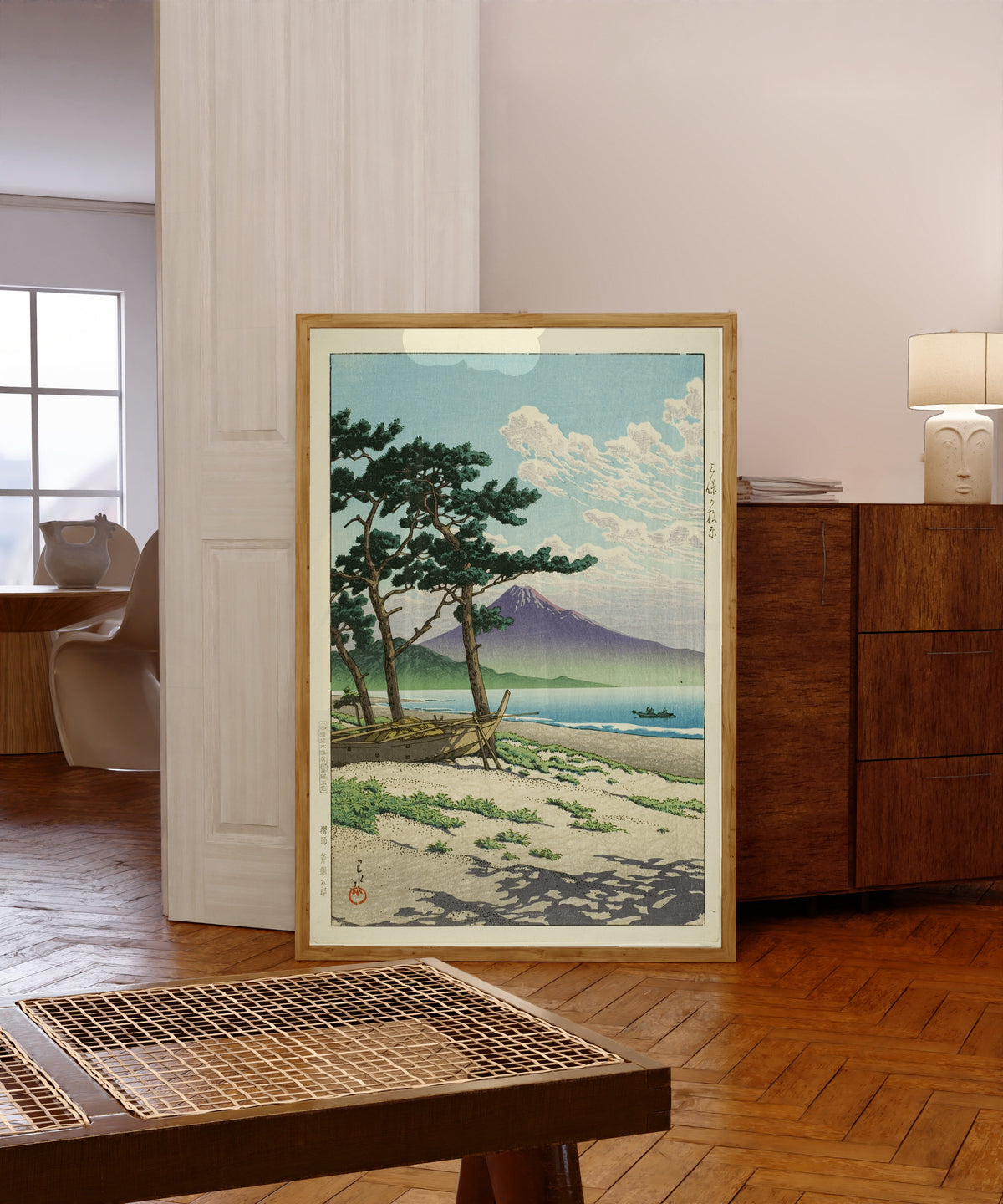 Framed art print of Pine Beach at Miho, Matsubara by Kawase Hasui, in a light wood frame leaning in a warm room with a parquet floor