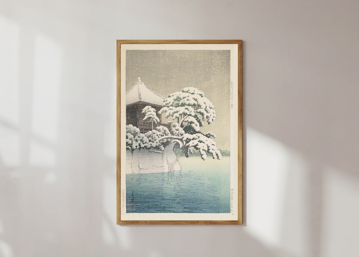 Framed art print of Snow at Godōidō, Matsushima by Kawase Hasui, in a light wood frame on a sunlit white wall