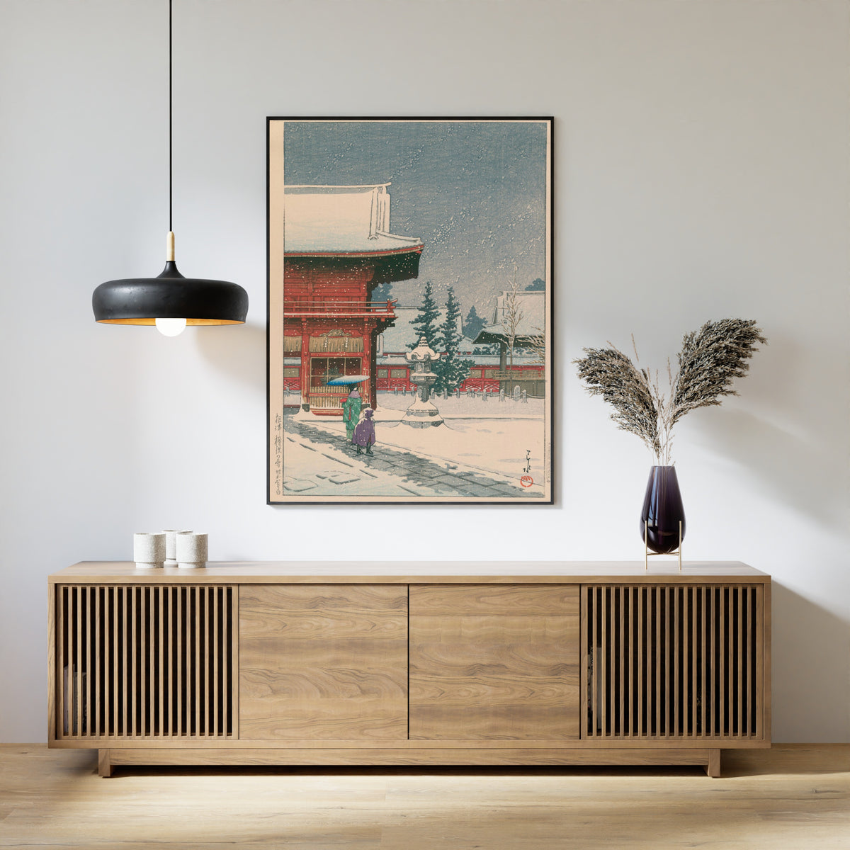 Framed art print of Snow at Nezu Gongen Shrine by Kawase Hasui, above a slatted wood sideboard