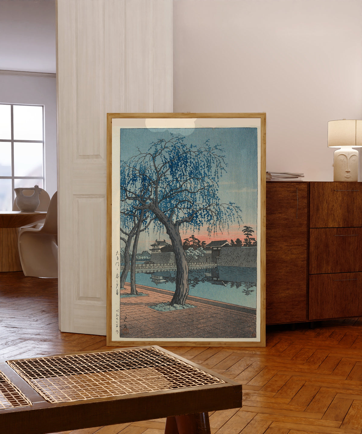 Framed art print of Spring Evening at Otemon Gate by Kawase Hasui, in a light wood frame leaning in a warm room with a parquet floor