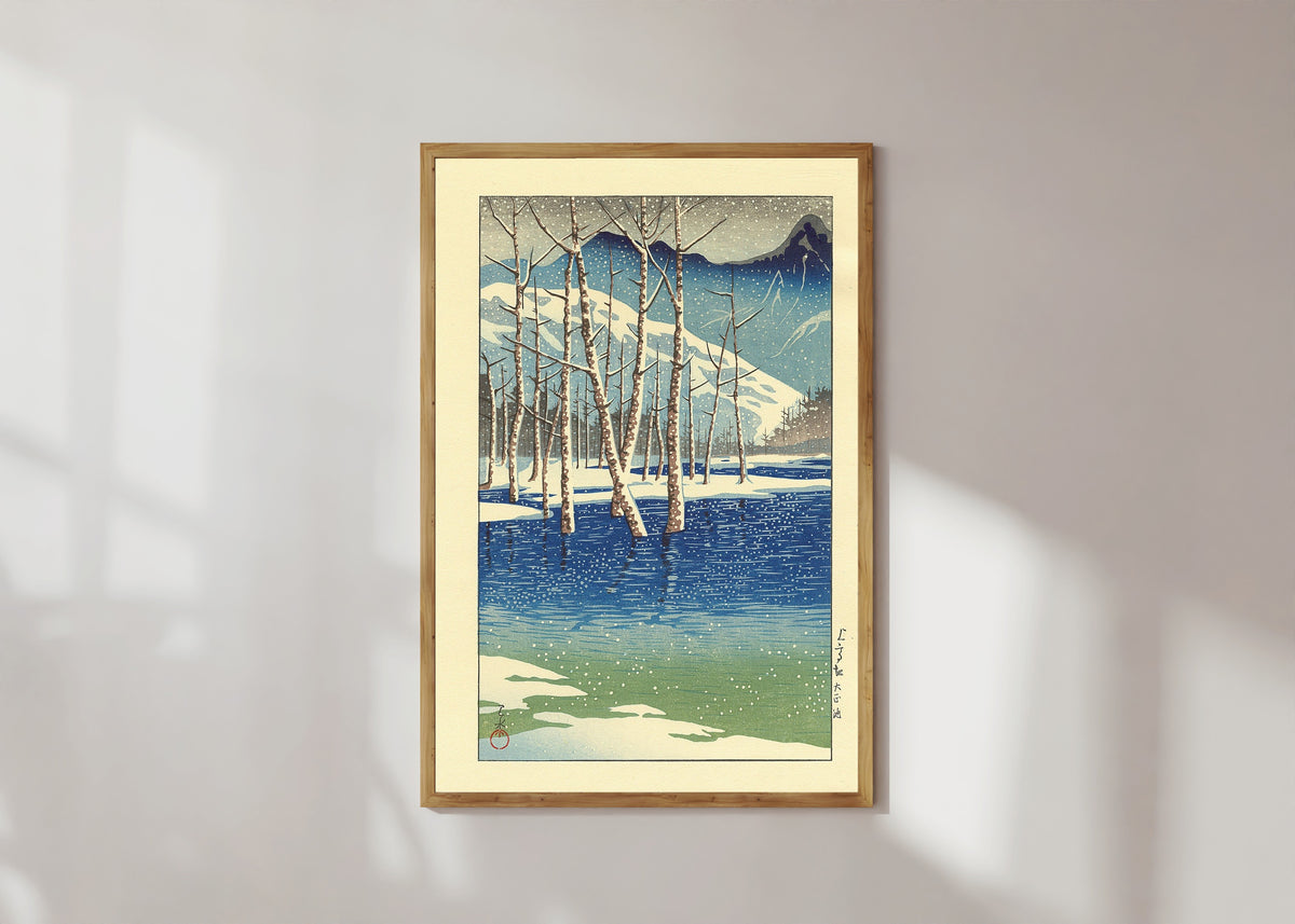 Framed art print of Taisho Pond by Kawase Hasui, in a light wood frame on a sunlit white wall