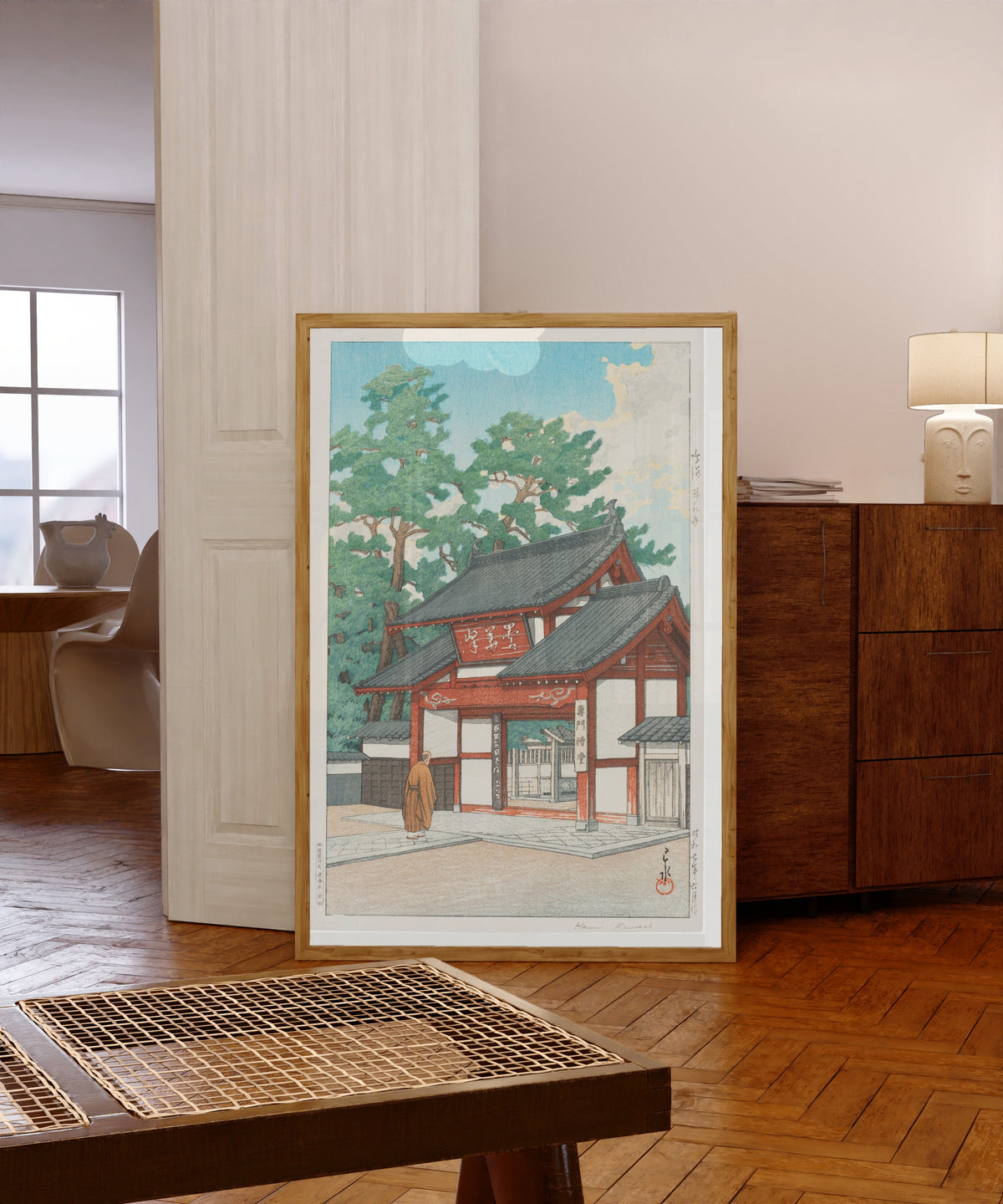 Framed art print of Zuisen Temple, Narumi by Kawase Hasui, in a light wood frame leaning in a warm room with a parquet floor