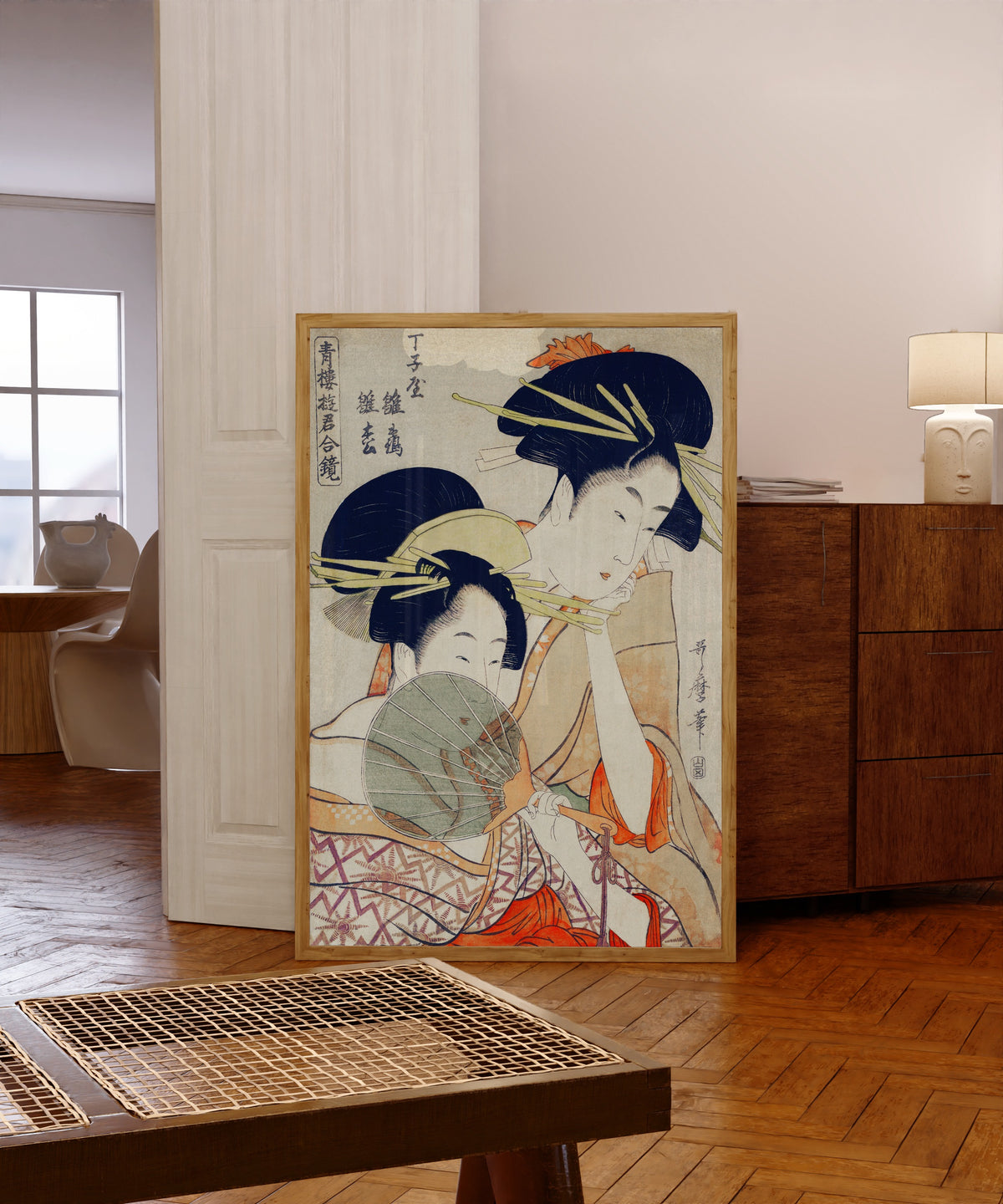 Framed art print of Chojiya Hinazuru Hinamatsu by Kitagawa Utamaro, in a light wood frame leaning in a warm room with a parquet floor