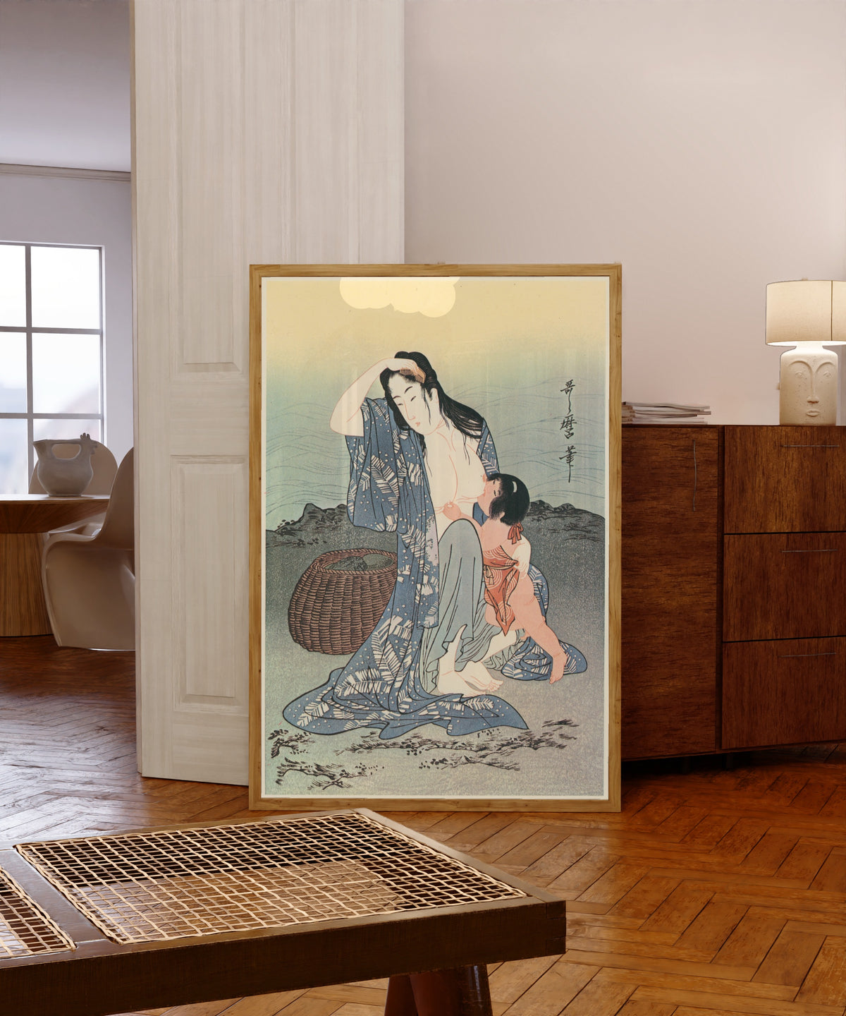 Framed art print of Diving for Abalones (Center) by Kitagawa Utamaro, in a light wood frame leaning in a warm room with a parquet floor