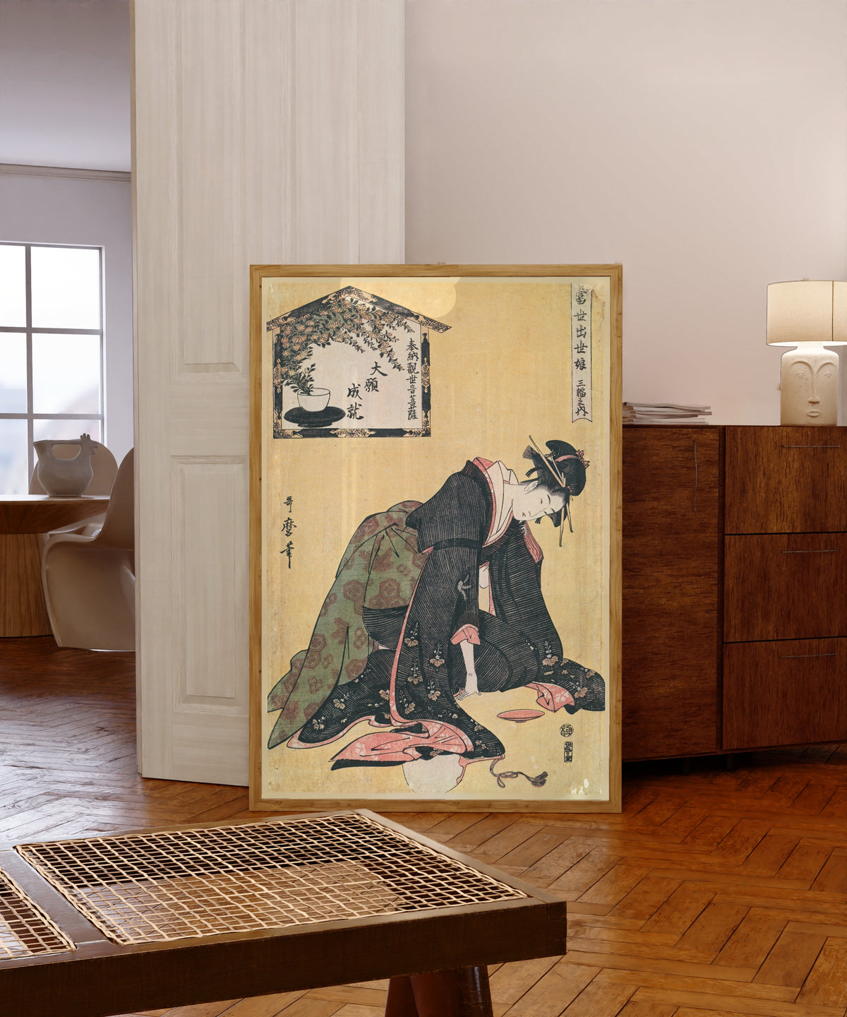 Framed art print of Naniwaya Okita, from Three Successful Girls of the… by Kitagawa Utamaro, in a light wood frame leaning in a warm room with a parquet floor