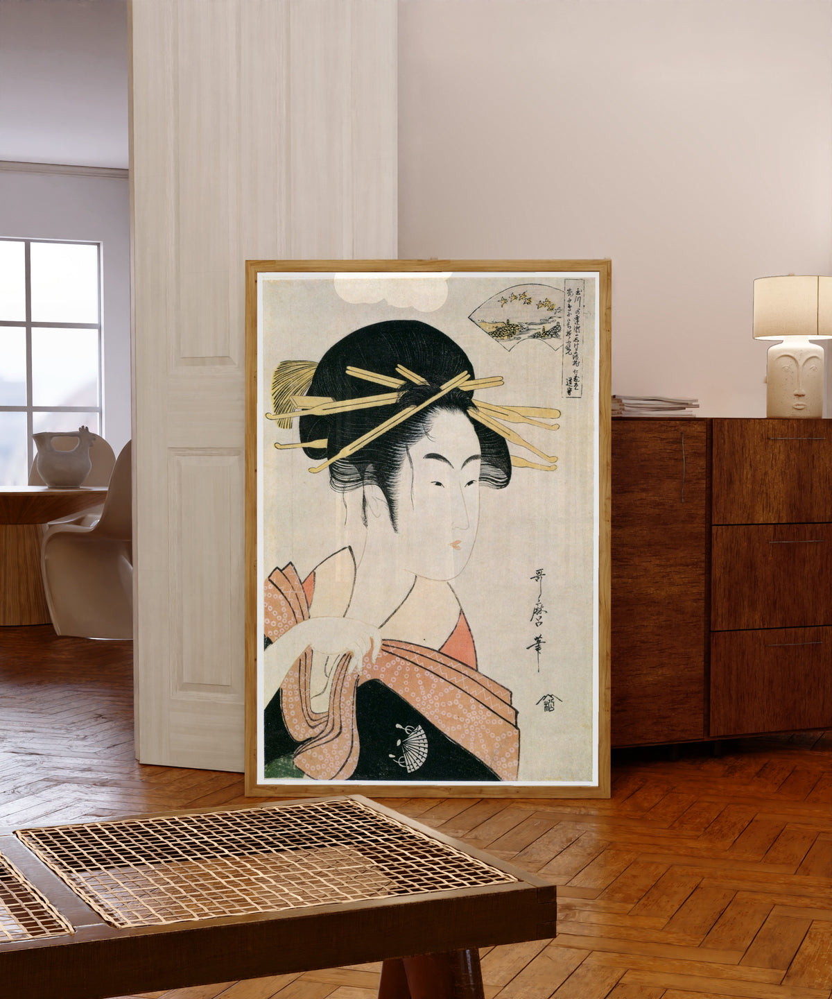 Framed art print of Noda Jewel River by Kitagawa Utamaro, in a light wood frame leaning in a warm room with a parquet floor