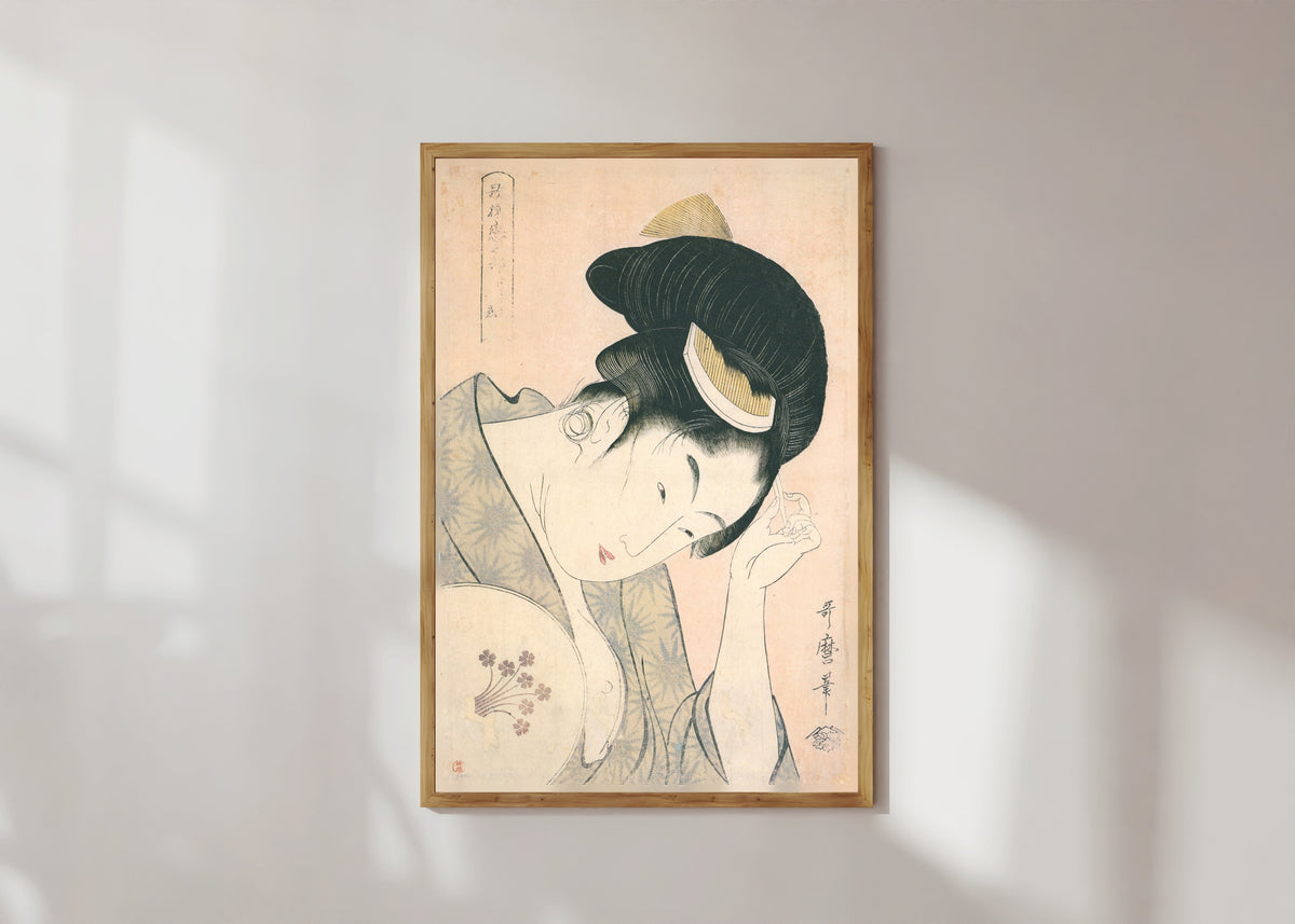 Framed art print of Revealed Love, from Anthology of Poems: The Love Section by Kitagawa Utamaro, in a light wood frame on a sunlit white wall