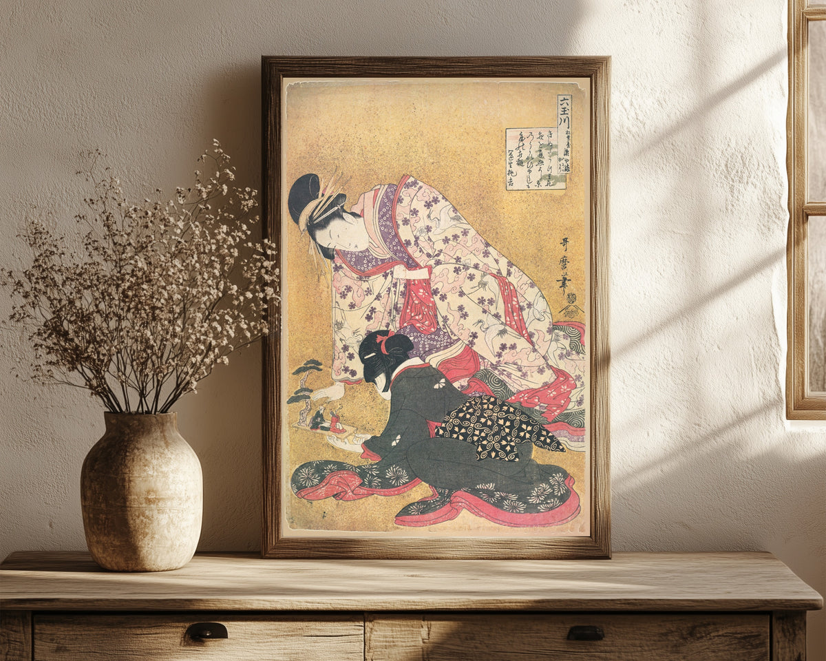 Framed art print of Seyama of the Matsubaya, kamuro Iroka and… by Kitagawa Utamaro, in a dark wood frame leaning on a rustic console beside dried flowers