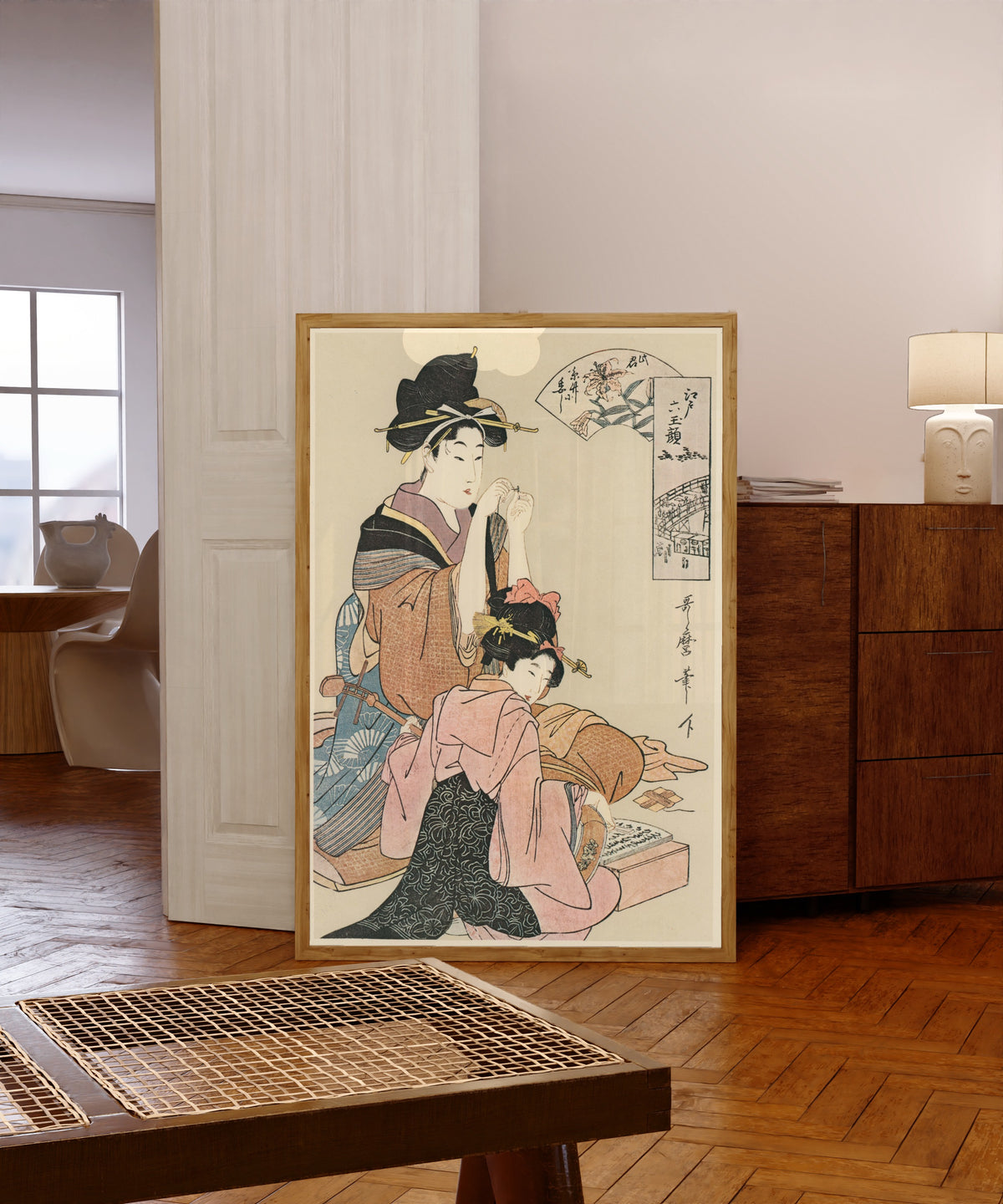Framed art print of Six Beauties of Edo by Kitagawa Utamaro, in a light wood frame leaning in a warm room with a parquet floor