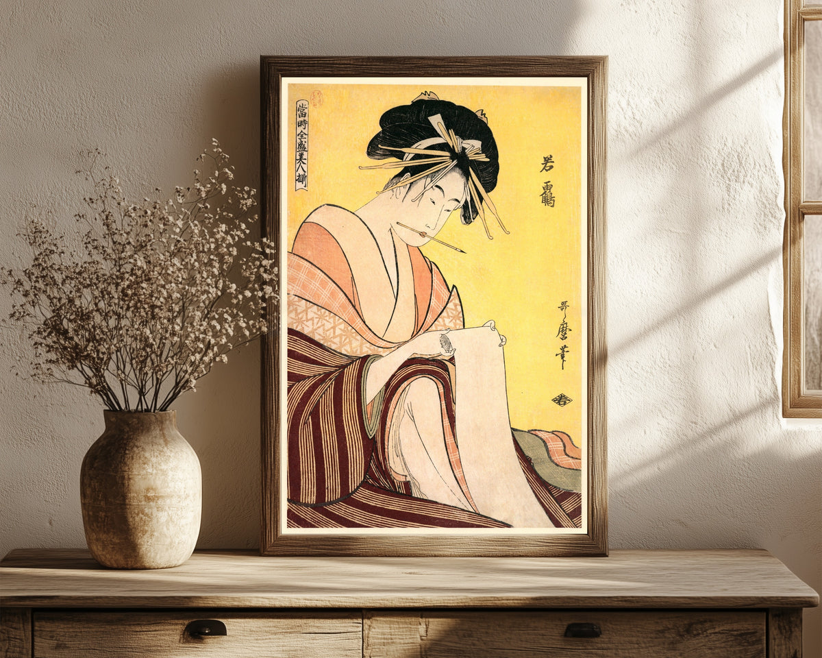 Framed art print of Wakatsuru by Kitagawa Utamaro, in a dark wood frame leaning on a rustic console beside dried flowers