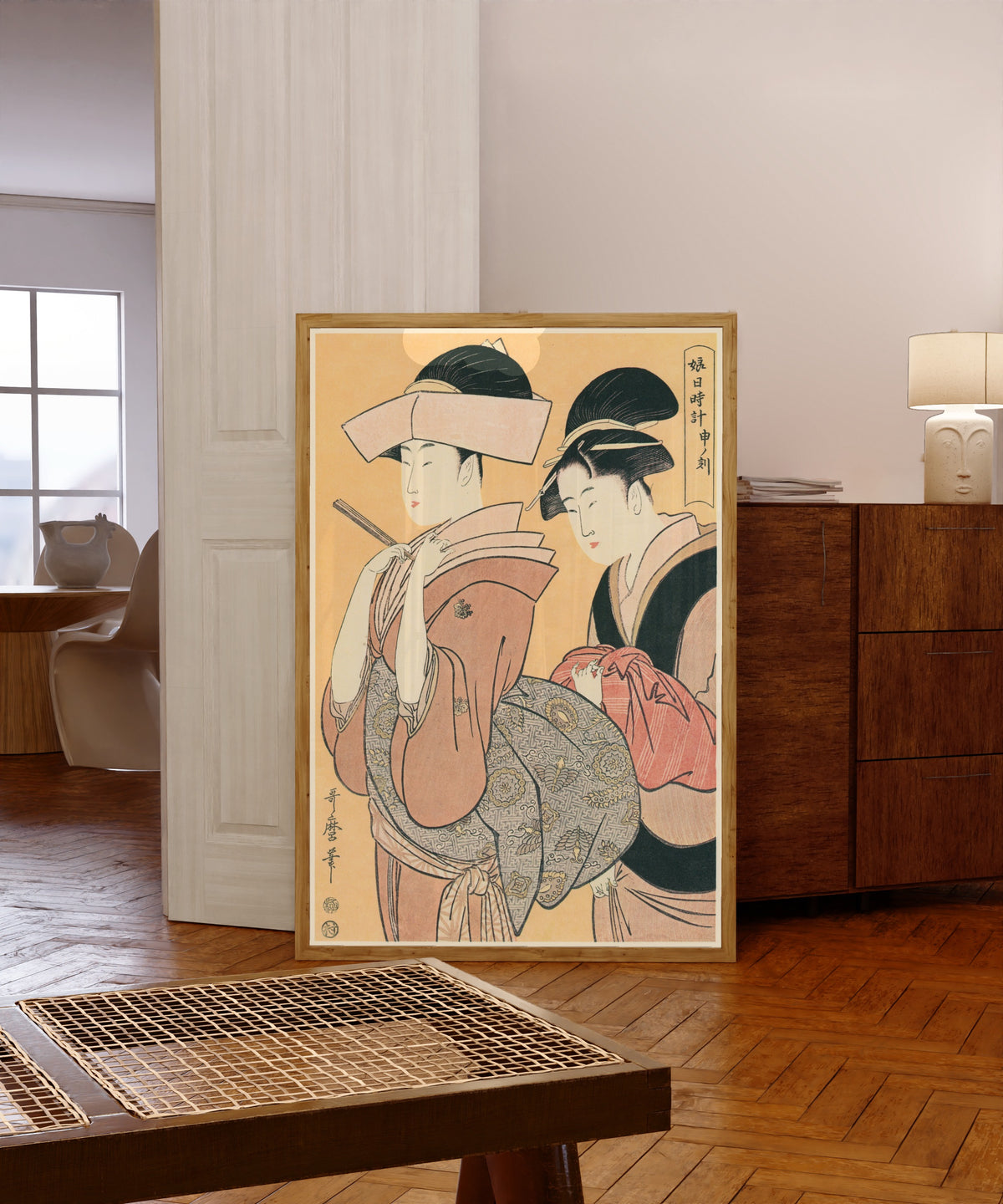 Framed art print of Woman Around the Clock at the Hour of the Monkey… by Kitagawa Utamaro, in a light wood frame leaning in a warm room with a parquet floor
