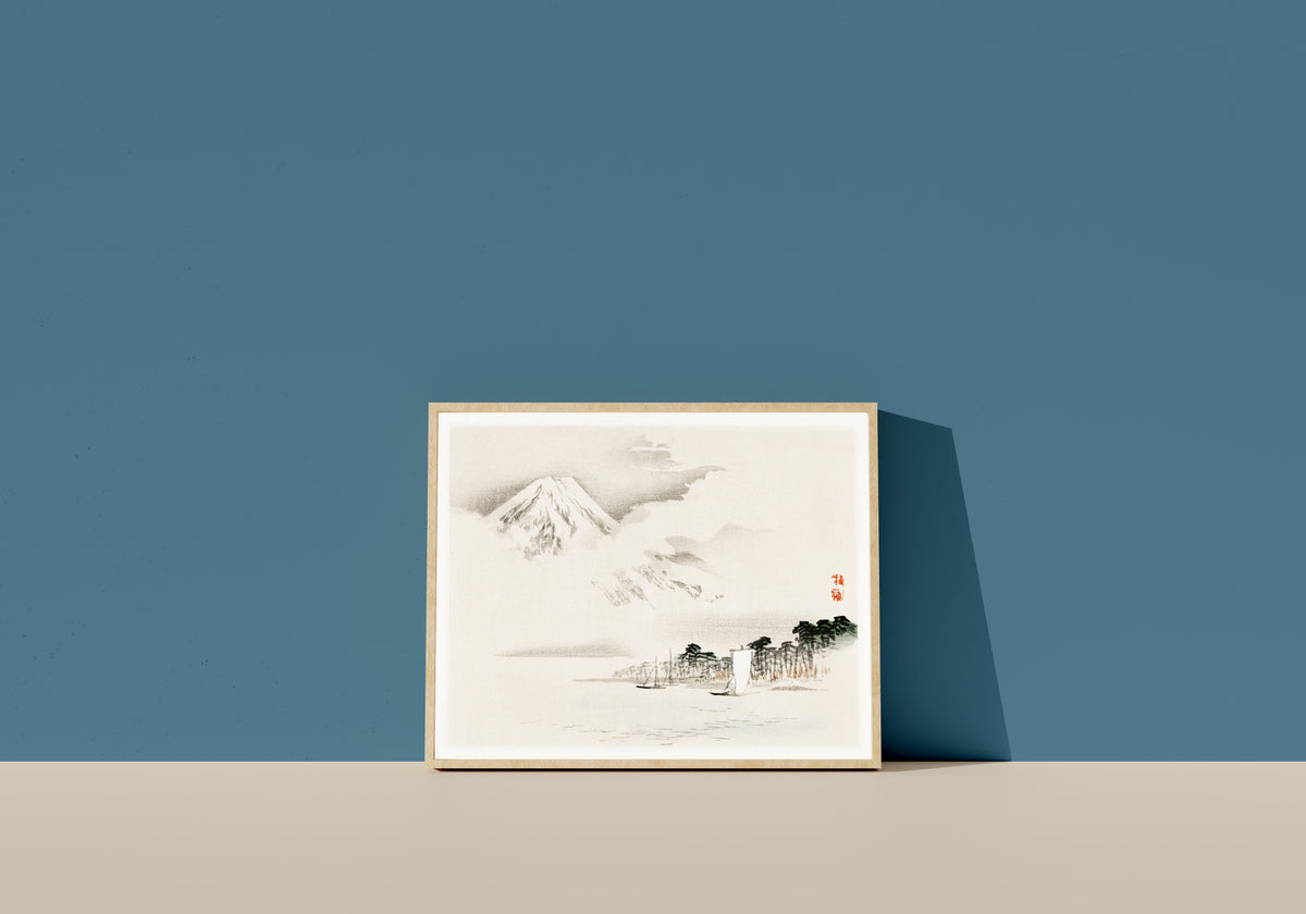 Framed art print of View of Mount Fuji by Kōno Bairei, in a light wood frame leaning on a blue wall