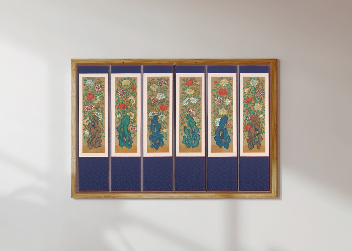 Framed art print of Peonies and Rocks by Korean minhwa painter (unidentified), in a light wood frame on a sunlit white wall