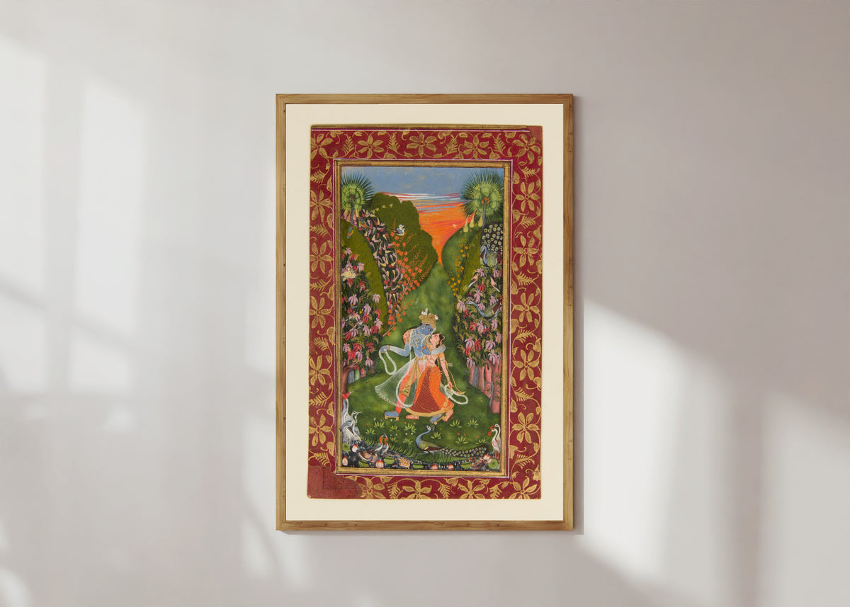 Framed art print of Radha and Krishna Walk in a Flowering Grove by Kota school, in a light wood frame on a sunlit white wall