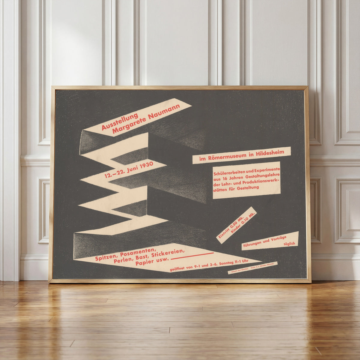 Framed art print of Ausstellung Margarete Naumann, Römermuseum Hildesheim by Kurt Schwitters, in a light wood frame leaning against a panelled white wall