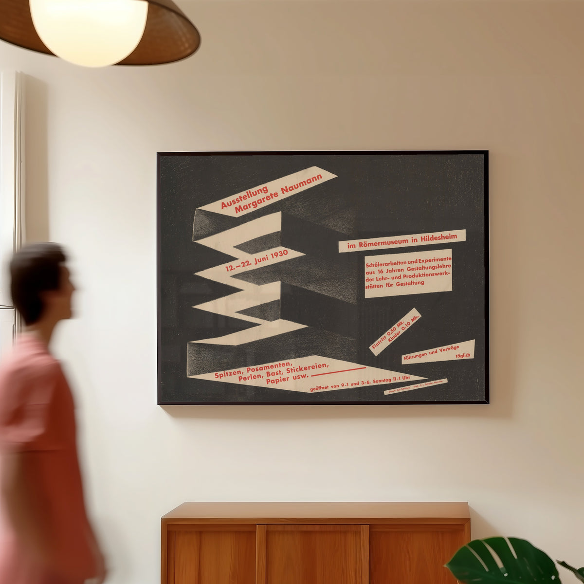 Framed art print of Ausstellung Margarete Naumann, Römermuseum Hildesheim by Kurt Schwitters, in a slim black frame on a warm wall in a sunlit room