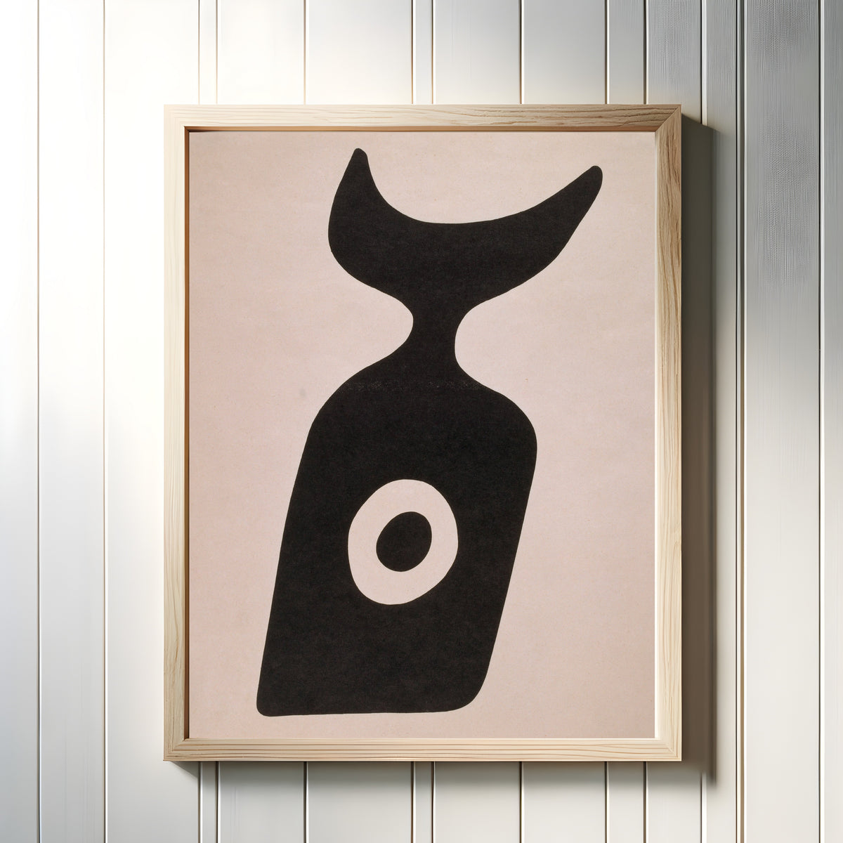 Framed art print of Die Nabelflasche by Kurt Schwitters, in a light wood frame on a white panelled wall