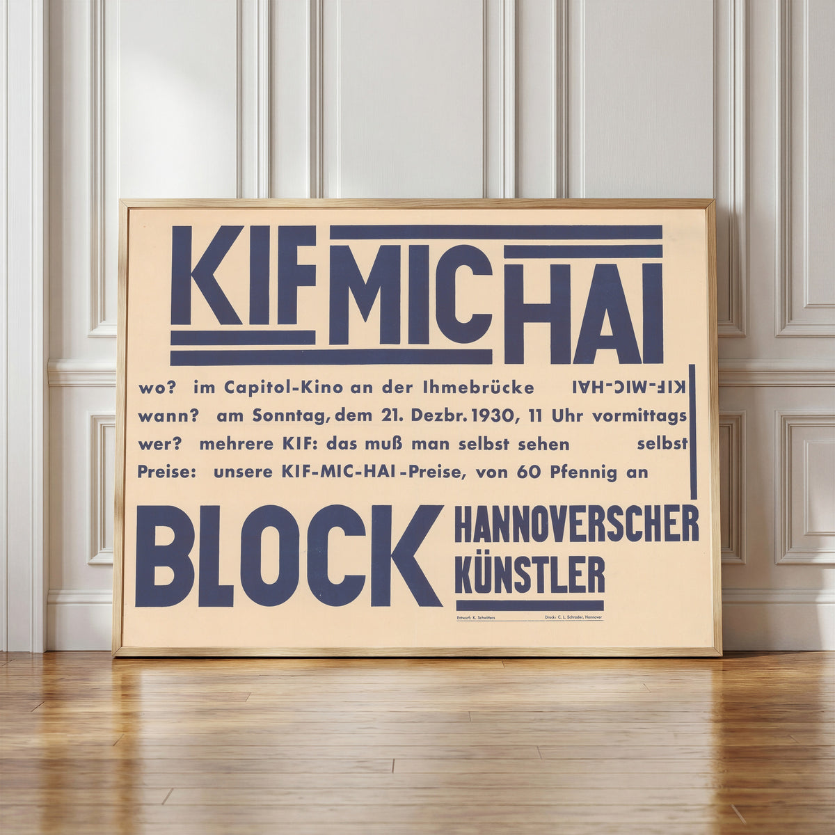 Framed art print of KIF MIC HAI, Block Hannoverscher Künstler by Kurt Schwitters, in a light wood frame leaning against a panelled white wall
