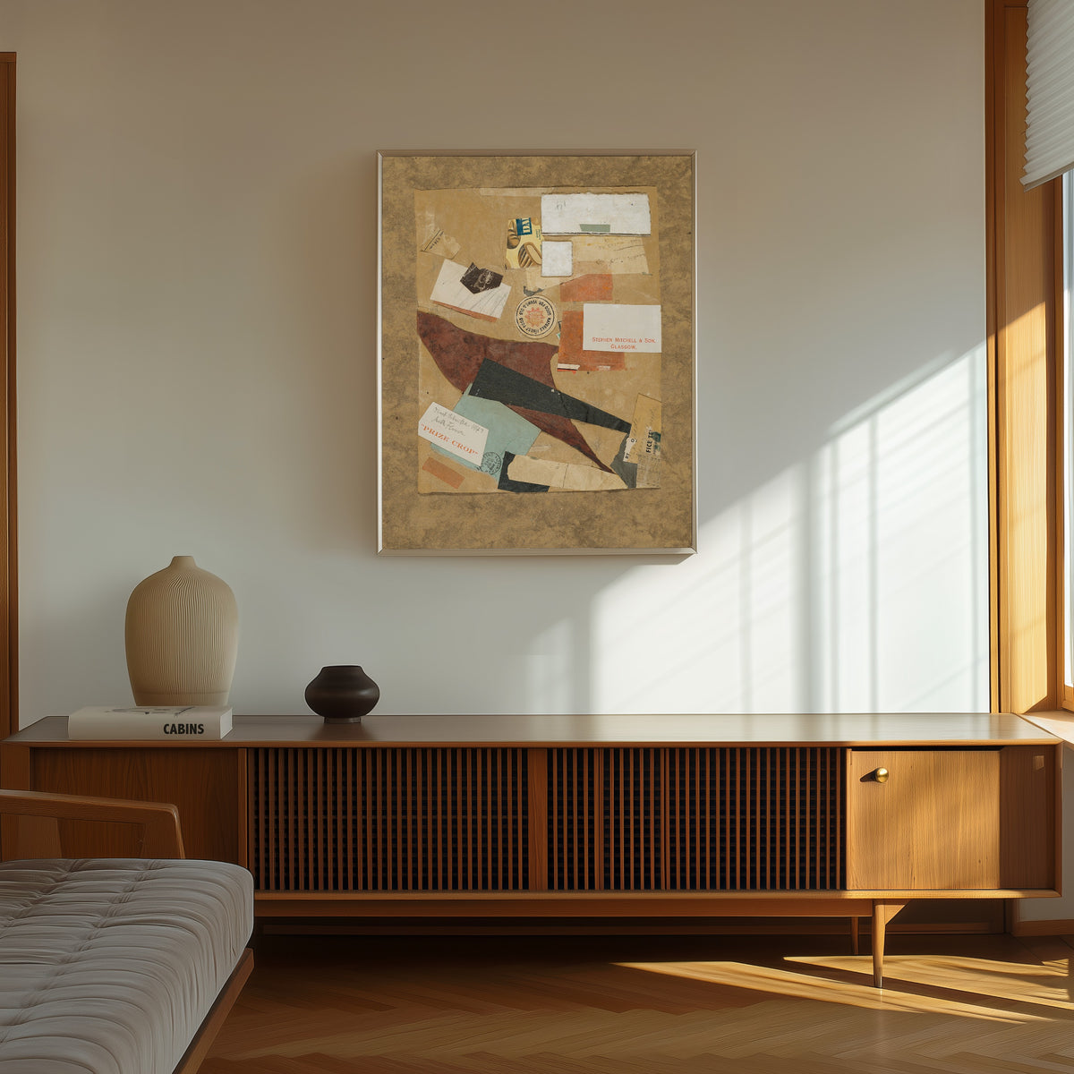 Framed art print of Milk Flower by Kurt Schwitters, in a thin light frame on a sunlit wall above a wooden sideboard